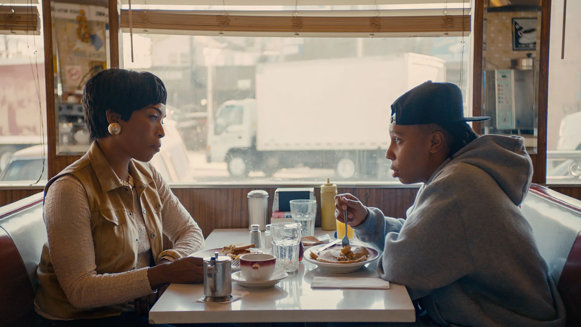Mother and daughter seated across from each other in a diner
